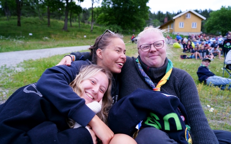 Speidere holder rundt hverandre på leirbål