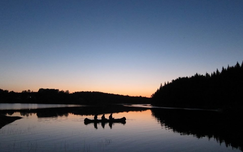 tre mennesker i kano solnedgang