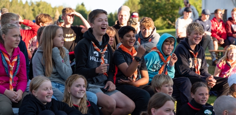 Leirbål hvor speidere smiler og ler