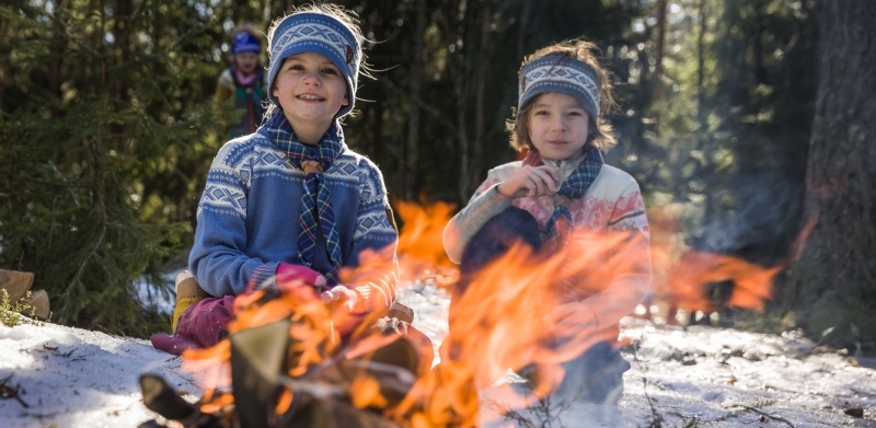 To små speidere sitter foran bålet